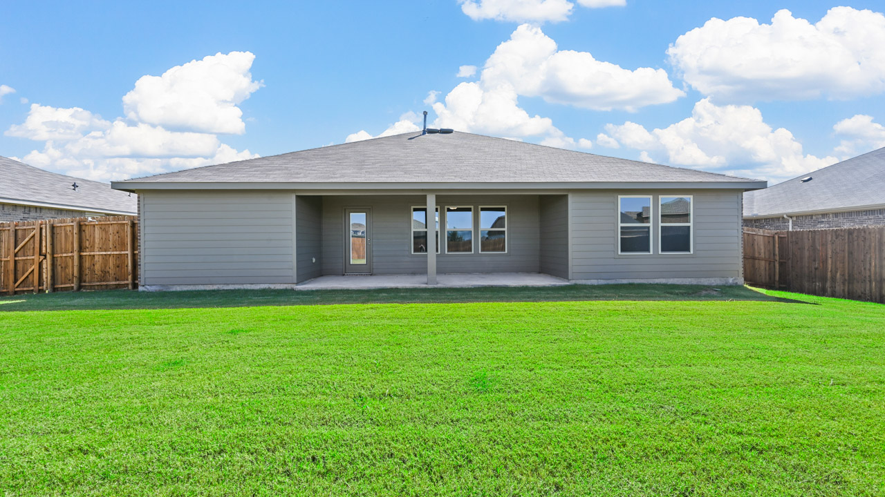 the back of a home with a covered patio and a wooden fence