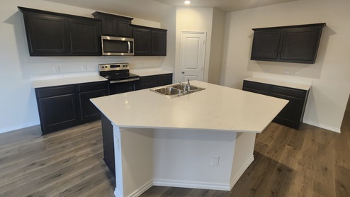 X50F kitchen area with white countertops and dark cabinets