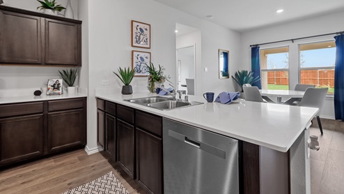 450 Lucky Lane at Bluff Springs in Ferris, TX kitchen with white counters and dark cabinets