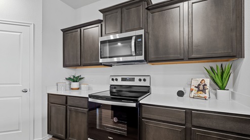 450 Lucky Lane at Bluff Springs in Ferris, TX kitchen area with white counters and dark cabinets