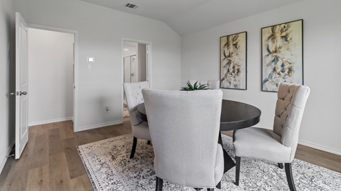 450 Lucky Lane at Bluff Springs in Ferris, TX primary bedroom with hardwood floors