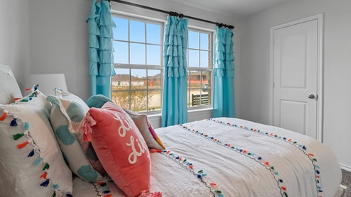 454 Lucky Lane at Bluff Springs in Ferris, TX secondary bedroom with carpet and large windows providing natural light