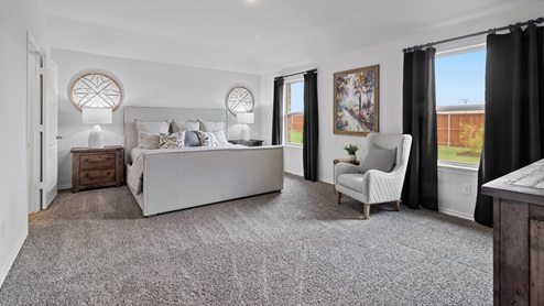 454 Lucky Lane at Bluff Springs in Ferris, TX primary bedroom with carpet and large windows