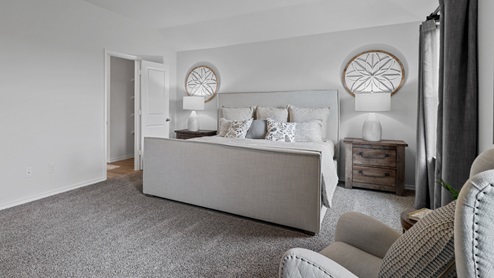 454 Lucky Lane at Bluff Springs in Ferris, TX primary bedroom with carpet and natural lighting