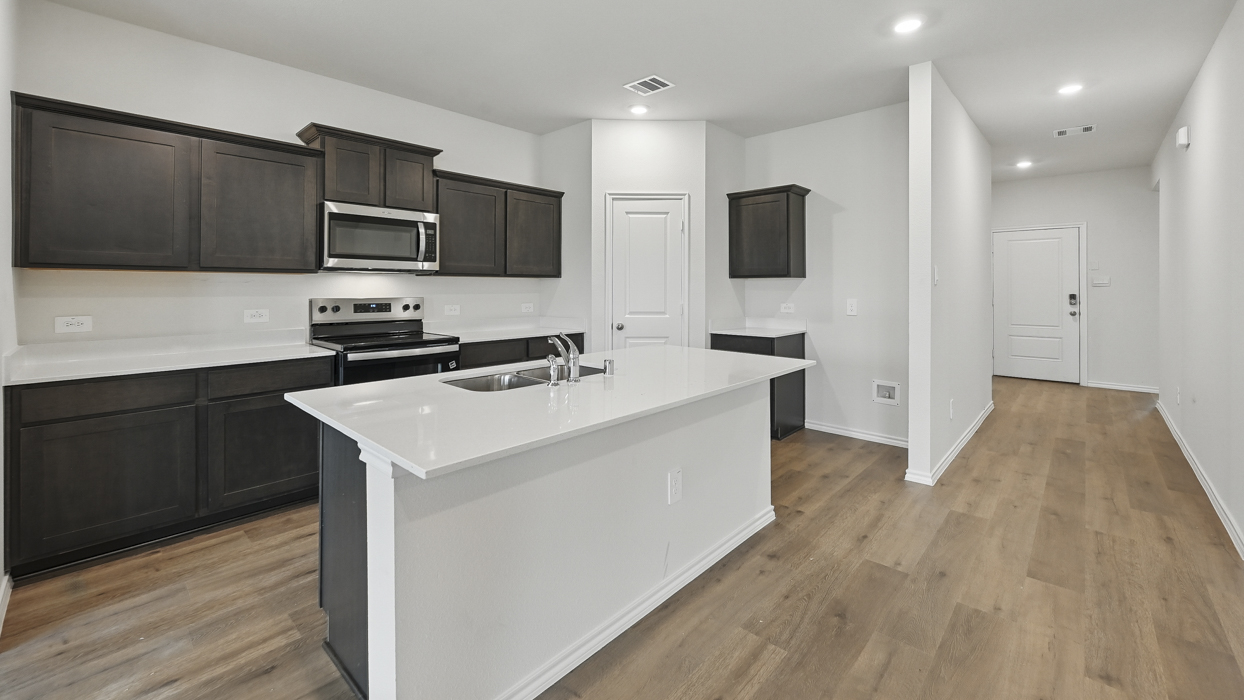 kitchen overview showing entry hallway with hardwood floors