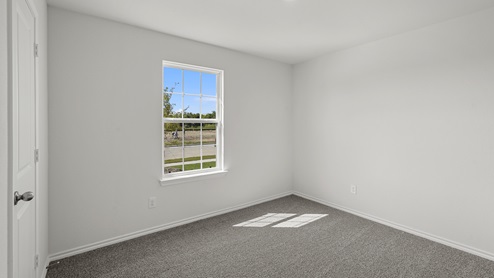 an empty bedroom with gray carpet and white walls