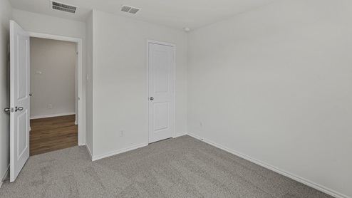 an empty bedroom with gray carpet and white walls