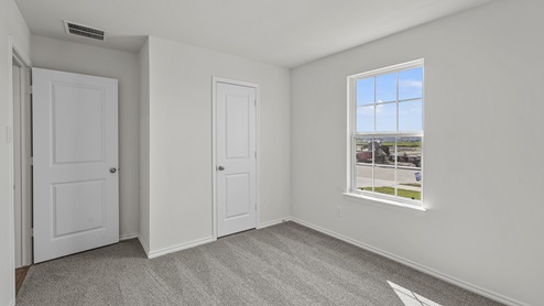 an empty bedroom with gray carpet and white walls