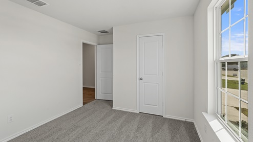 an empty bedroom with gray carpet and white walls