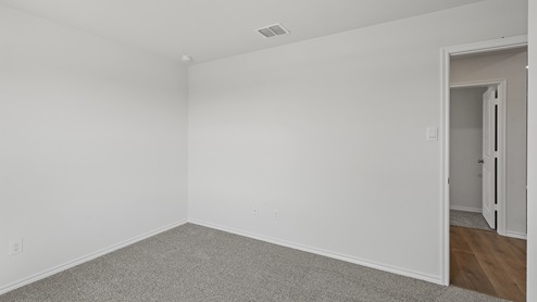 an empty bedroom with gray carpet and white walls