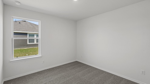 an empty bedroom with gray carpet and white walls