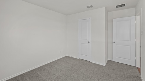 an empty bedroom with gray carpet and white walls