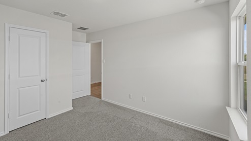 an empty bedroom with gray carpet and white walls