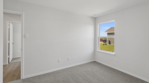 an empty bedroom with gray carpet and white walls