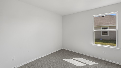 an empty bedroom with gray carpet and white walls