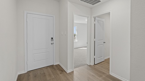 entryway of a home with white walls and wood floors
