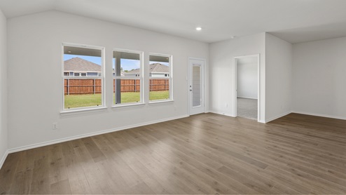 an open living room with white walls and wood floors