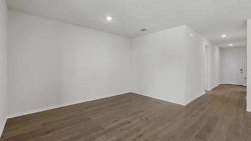 an open living room with white walls and wood floors