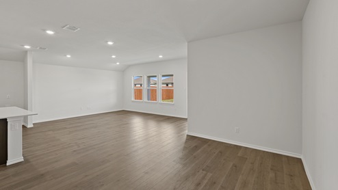 an open living room with white walls and wood floors