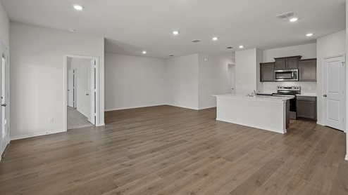 an open living room with white walls and wood floors