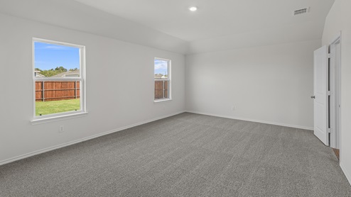 an empty bedroom with gray carpet and white walls