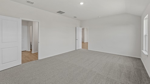 an empty bedroom with gray carpet and white walls