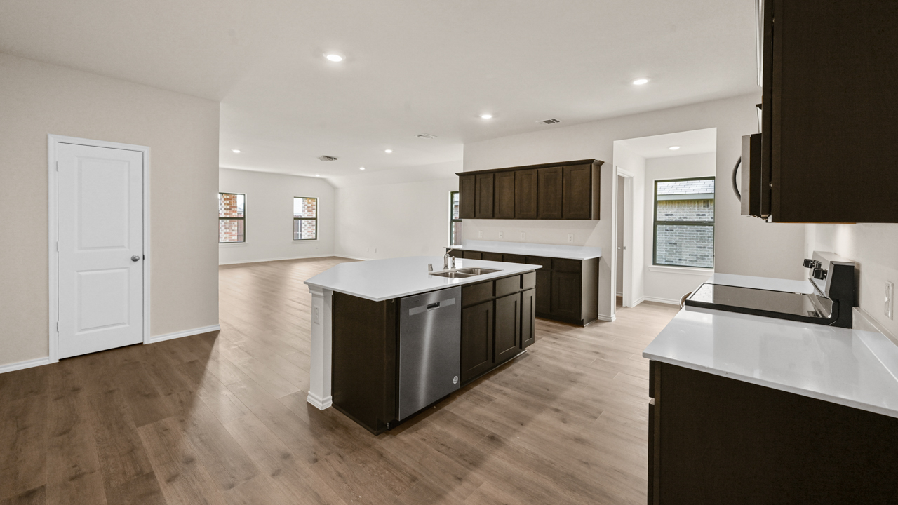a kitchen with dark cabinets and an island in the middle