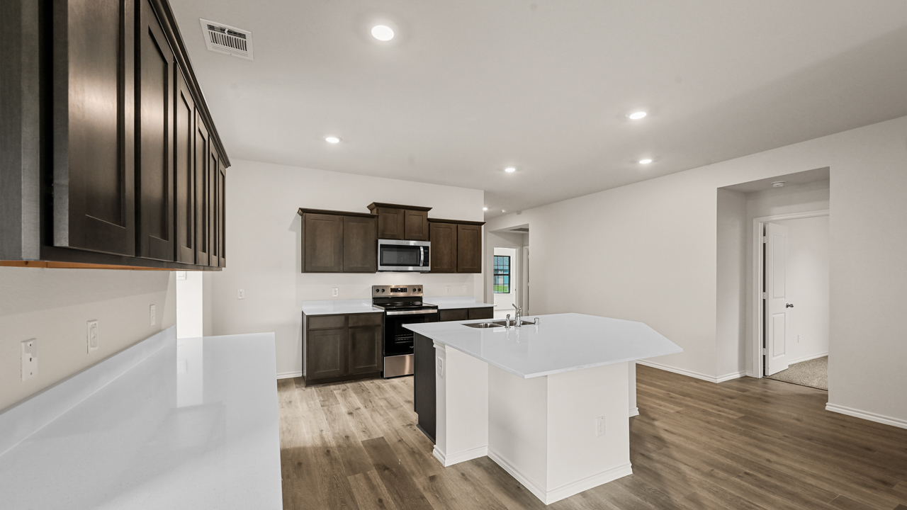 a kitchen with dark cabinets and an island in the middle