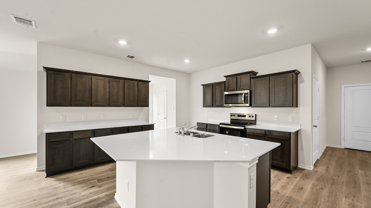 a kitchen with dark cabinets and an island in the middle