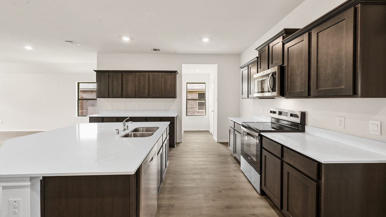 a kitchen with dark cabinets and an island in the middle