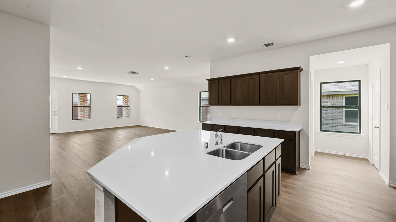 a kitchen with dark cabinets and an island in the middle