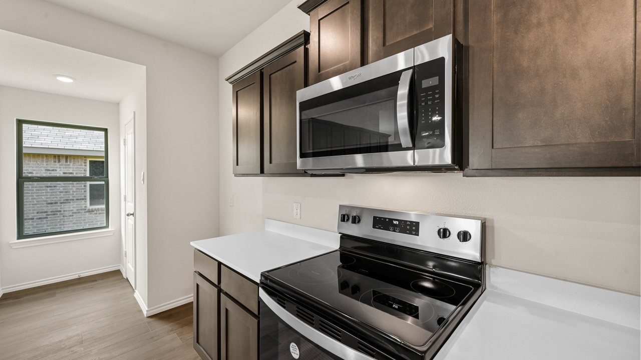 a kitchen with dark cabinets and an island in the middle