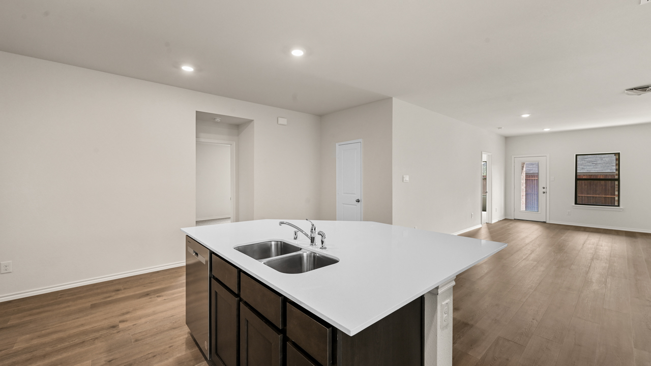 a kitchen with dark cabinets and an island in the middle