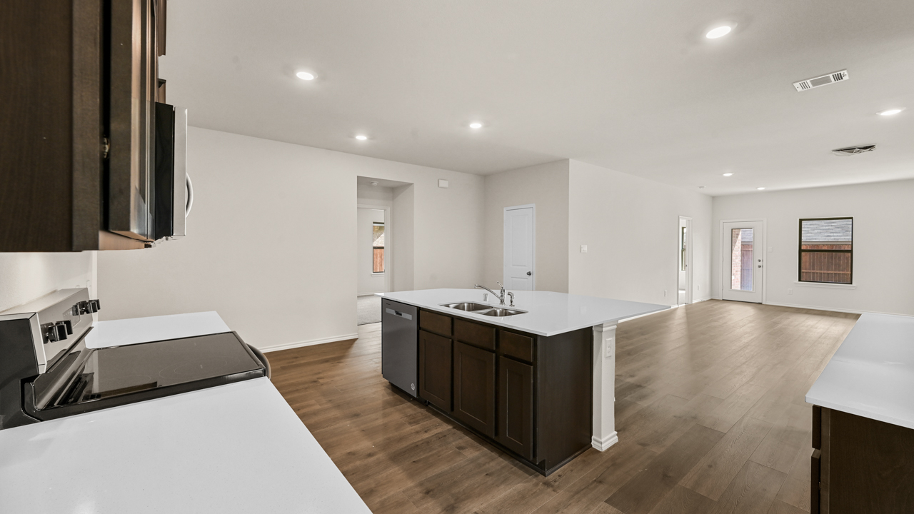 a kitchen with dark cabinets and an island in the middle