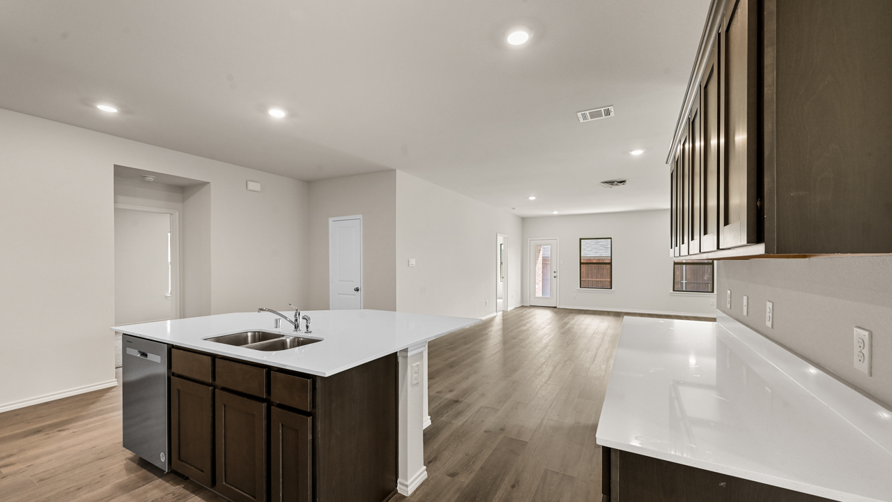 a kitchen with dark cabinets and an island in the middle