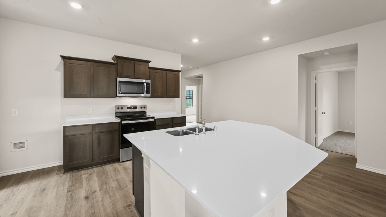 a kitchen with dark cabinets and an island in the middle