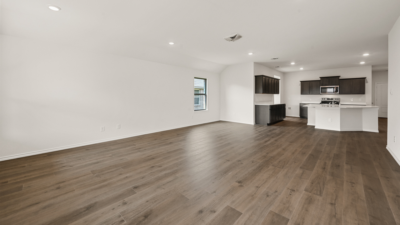 an empty living area with white walls and wood floors