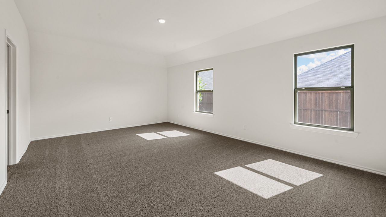 an empty bedroom with gray carpet and white walls
