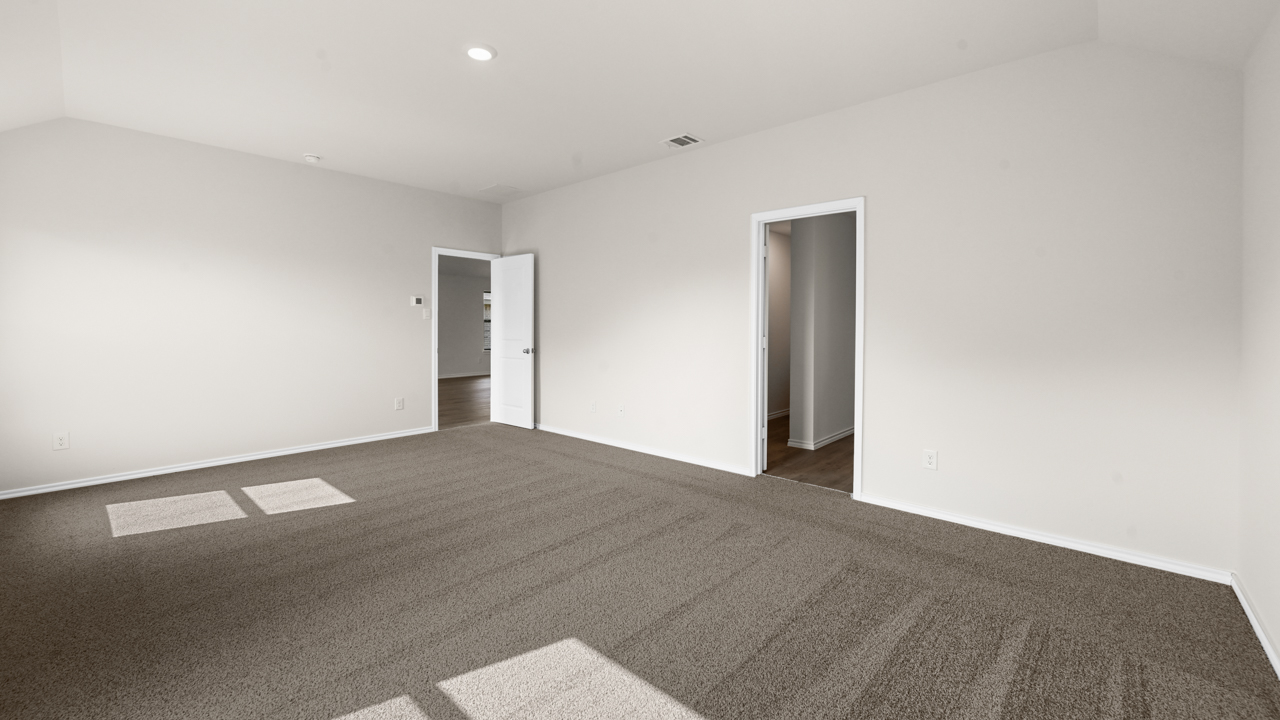 an empty bedroom with gray carpet and white walls