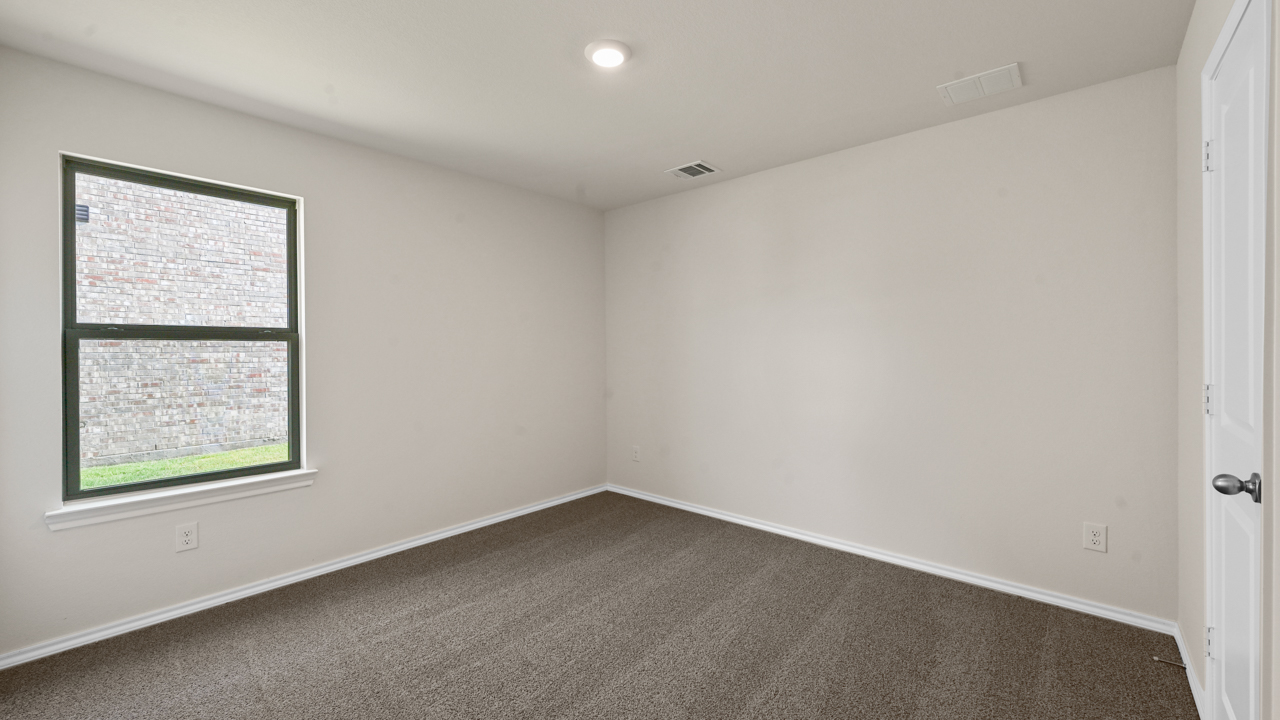 an empty bedroom with gray carpet and white walls