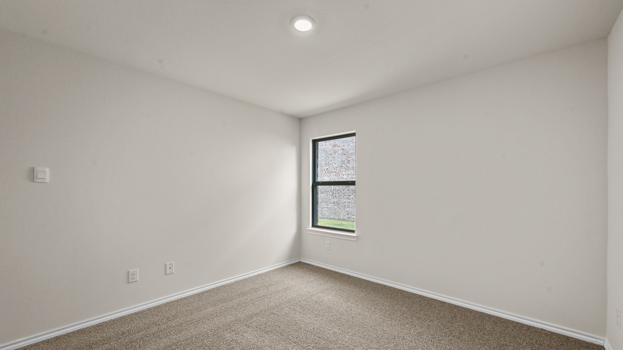 an empty bedroom with gray carpet and white walls