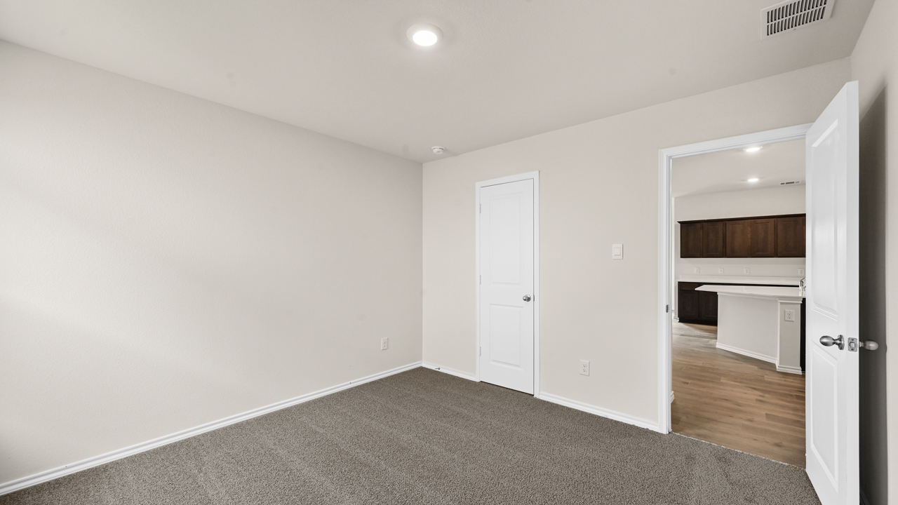 an empty bedroom with gray carpet and white walls