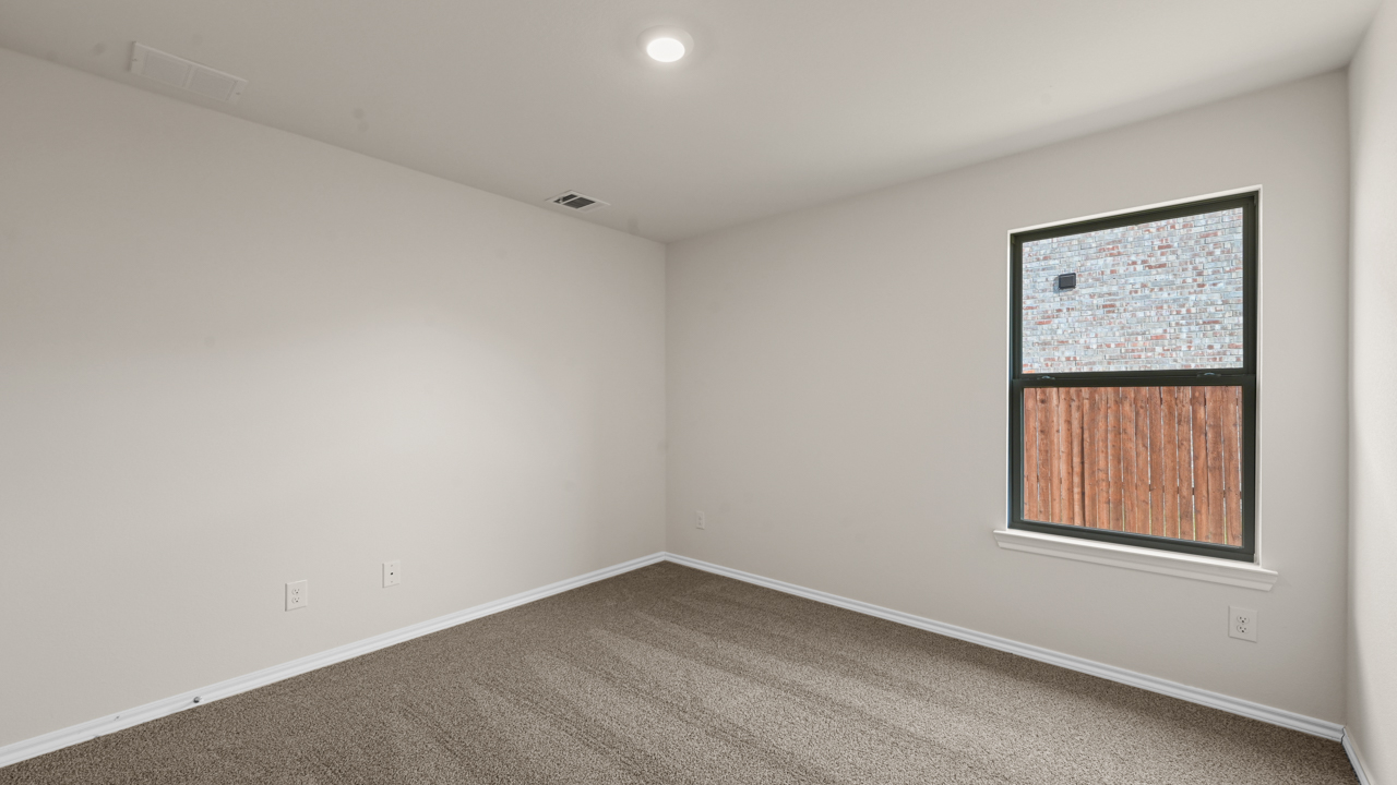 an empty bedroom with gray carpet and white walls