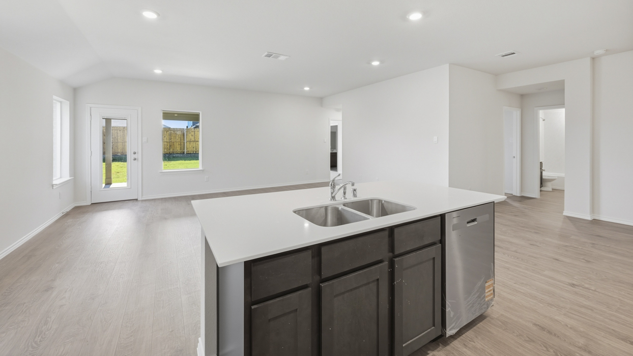 kitchen view overlooking island, living room and entrance to secondary bedrooms