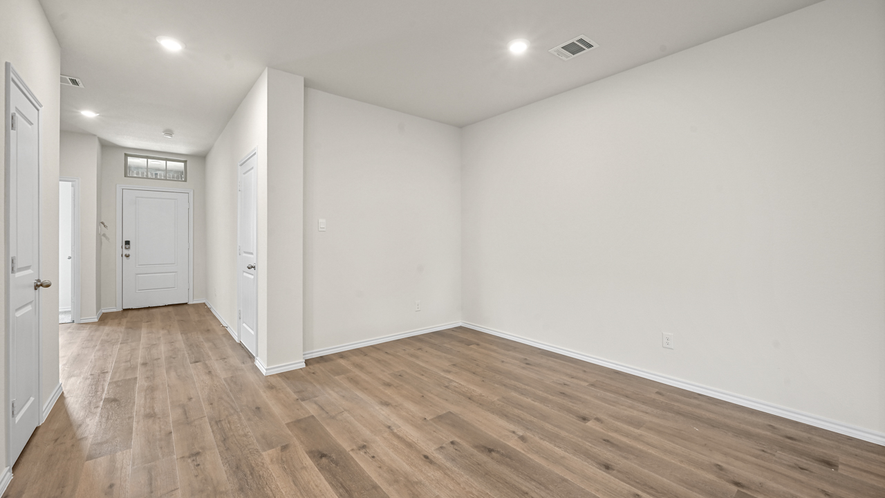 an open living room with wood floors and white walls