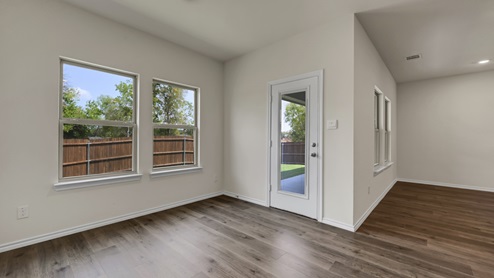 an open living area with wood floors and white walls