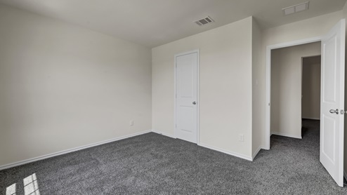 an empty bedroom with gray carpet and white walls