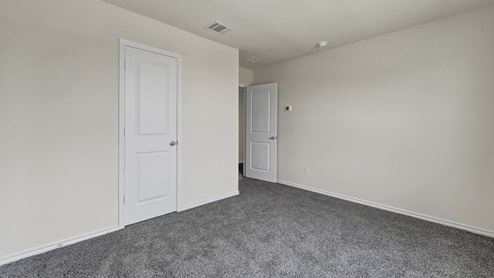an empty bedroom with gray carpet and white walls