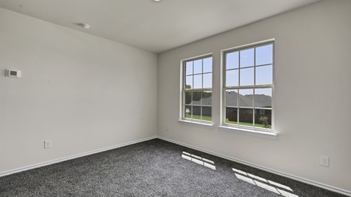 an empty bedroom with gray carpet and white walls