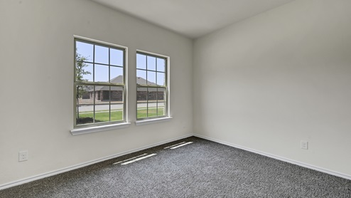 an empty bedroom with gray carpet and white walls